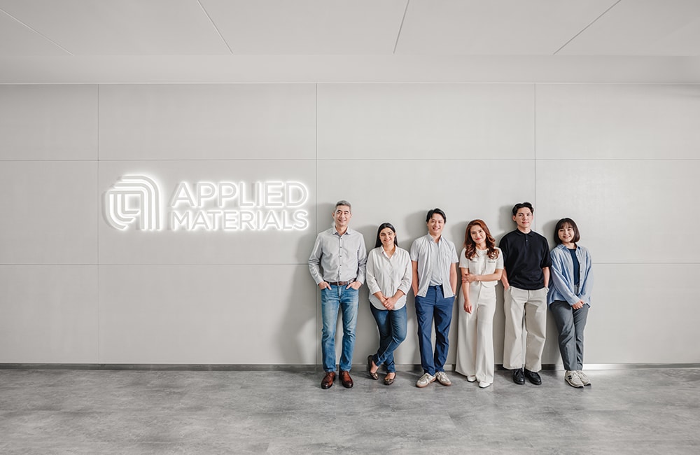 group of employees by Applied Materials sign